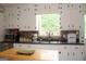 Well-lit kitchen featuring a stainless steel dishwasher, ample counter space, and stylish cabinetry, perfect for meal preparation at 124 Wynn Rd, Mcdonough, GA 30252