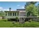Backyard view featuring a sunroom, deck, stairs, and a lush green lawn at 4117 Signal Sw Rdg, Lilburn, GA 30047