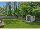 Backyard featuring a well-maintained lawn, wooden fence, and storage shed at 4117 Signal Sw Rdg, Lilburn, GA 30047