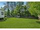 Spacious backyard with a large green lawn, storage shed, and wooden fence at 4117 Signal Sw Rdg, Lilburn, GA 30047