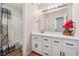 Bright bathroom featuring a tub/shower combo, decorative curtain, and vanity with framed mirror at 4117 Signal Sw Rdg, Lilburn, GA 30047