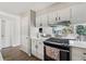 Kitchen with modern appliances, stone countertops and opens to a dining room and backyard view at 4117 Signal Sw Rdg, Lilburn, GA 30047