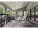 Stylish sunroom with hardwood floors, a ceiling fan, comfortable seating, and an abundance of natural light at 4117 Signal Sw Rdg, Lilburn, GA 30047