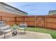 Cozy backyard featuring a wood fence, a small patio with chairs, and a well-maintained lawn at 7682 Baron Rd, Fairburn, GA 30213