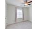 Bright bedroom featuring neutral carpet, a ceiling fan, and a window with blinds and curtains at 7682 Baron Rd, Fairburn, GA 30213
