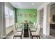 Dining room with modern glass table, white chairs, and green accent wall at 7682 Baron Rd, Fairburn, GA 30213