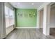 Dining area with a green accent wall, natural light, and modern light fixtures at 7682 Baron Rd, Fairburn, GA 30213