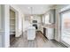 Bright eat-in kitchen features an island, pendant lighting, stainless appliances and exterior access at 7682 Baron Rd, Fairburn, GA 30213