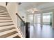 Open concept living room with fireplace, ceiling fan, and staircase at 7682 Baron Rd, Fairburn, GA 30213