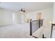 Open loft area with carpet flooring, ceiling fan, and a view of the staircase at 7682 Baron Rd, Fairburn, GA 30213