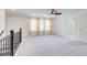 Carpeted loft area with bright natural lighting, ceiling fan and railing at 7682 Baron Rd, Fairburn, GA 30213