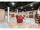 Spacious finished basement with exposed ceiling and red sofa and colorful rug at 1083 Wash Lee Sw Dr, Lilburn, GA 30047
