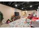 Basement with TV, exposed ceiling, living area, and colorful rug at 1083 Wash Lee Sw Dr, Lilburn, GA 30047