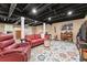 Cozy basement with exposed ceiling, living area, TV, and colorful rug at 1083 Wash Lee Sw Dr, Lilburn, GA 30047