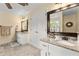 Bright bathroom featuring dual granite-topped vanities and a decorative mirror at 1083 Wash Lee Sw Dr, Lilburn, GA 30047