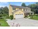 Yellow home featuring an attached garage, well maintained lawn and driveway at 1083 Wash Lee Sw Dr, Lilburn, GA 30047
