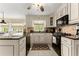 Charming kitchen with white cabinets, granite countertops, tile backsplash, and modern black stainless steel appliances at 1083 Wash Lee Sw Dr, Lilburn, GA 30047