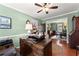 Well-lit home office featuring a wooden desk, ceiling fan, and stylish decor with an open view to the dining area at 1083 Wash Lee Sw Dr, Lilburn, GA 30047
