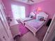 Purple bedroom with two twin beds, a white dresser, and a rainbow window covering at 2331 Georgia Lane, Snellville, GA 30078