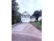 Charming two-story home with a manicured lawn and a long driveway leading to an attached garage at 2331 Georgia Lane, Snellville, GA 30078