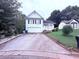 Charming two-story home featuring a well-maintained lawn, attached garage, and a long driveway at 2331 Georgia Lane, Snellville, GA 30078