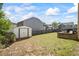 Spacious backyard with a storage shed and a stone retaining wall, offering ample space for outdoor activities at 543 Walnut Way, Palmetto, GA 30268
