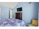 Bedroom with blue walls, TV, wood dresser, and a bed with a blue quilt in a well-lit room at 543 Walnut Way, Palmetto, GA 30268
