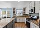 Well-lit kitchen features stainless steel appliances, granite countertops, and ample cabinet space at 543 Walnut Way, Palmetto, GA 30268