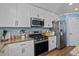 Well-equipped kitchen with stainless steel appliances, granite counters, and bright white cabinets at 543 Walnut Way, Palmetto, GA 30268