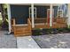 Inviting front porch with fresh stone, landscaped yard, and a charming red door at 1321 Bridges Sw Ave, Atlanta, GA 30310