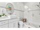 Bright bathroom featuring marble walls, a glass shower, modern fixtures, and a white vanity at 1450 Elizabeth Ln, Atlanta, GA 30344