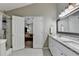 Bright bathroom featuring a double vanity with granite countertops and a large mirror, complemented by modern lighting fixtures at 1627 Amhearst Walk Rd, Lawrenceville, GA 30043