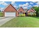 Charming, one-story brick home with well-maintained lawn, a two-car garage, and lush landscaping at 1627 Amhearst Walk Rd, Lawrenceville, GA 30043