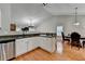 Bright kitchen with white cabinetry and stainless steel appliances that opens to a dining space at 1627 Amhearst Walk Rd, Lawrenceville, GA 30043