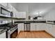 A stylish kitchen with stainless steel appliances and hardwood floors that extend into the living space at 1627 Amhearst Walk Rd, Lawrenceville, GA 30043