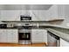 White kitchen with stainless steel appliances, ample counter space, and bright lighting at 1627 Amhearst Walk Rd, Lawrenceville, GA 30043