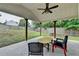 Covered patio with ceiling fan and stone floor overlooking a fenced yard at 1627 Amhearst Walk Rd, Lawrenceville, GA 30043