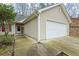 Close up of a home's exterior featuring a white garage door and light beige siding at 300 Lakeside Dr, Covington, GA 30016
