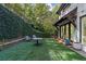 Beautiful backyard featuring artificial turf, ivy-covered slope, and outdoor seating at 6305 River Chase Cir, Atlanta, GA 30328