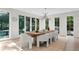 Stylish dining area with modern lighting, hardwood floors, and a view of the landscaped backyard at 6305 River Chase Cir, Atlanta, GA 30328