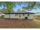 A white brick house features a well-kept lawn and a small back patio with steps at 2244 Alpha Dr, Decatur, GA 30032