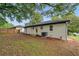 View of the back exterior of a house with a white brick wall and a large backyard at 2244 Alpha Dr, Decatur, GA 30032