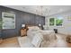 Bright bedroom boasts hardwood floors, stylish chandelier and accent wall at 2244 Alpha Dr, Decatur, GA 30032