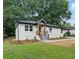 Landscaped front yard showcases a white brick house with black trim and modern wood porch at 2244 Alpha Dr, Decatur, GA 30032