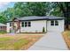 Charming renovated brick home with wood porch, new driveway, and green lawn at 2244 Alpha Dr, Decatur, GA 30032