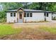 Charming renovated brick home with wood porch, concrete stairs, and green lawn at 2244 Alpha Dr, Decatur, GA 30032