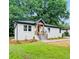 Charming renovated brick home with wood porch, new landscaping, and green lawn at 2244 Alpha Dr, Decatur, GA 30032