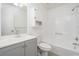 White bathroom featuring single vanity, tub-shower combo and bright lighting at 3066 Malvern Dr, Snellville, GA 30039