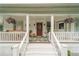 Inviting front porch with steps, seating, hanging plants, and a beautifully decorated front door with a wreath at 4527 Dallas St, Acworth, GA 30101