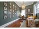 A green office with a stylish chandelier, hardwood floors, and wall art at 4527 Dallas St, Acworth, GA 30101